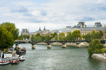 Fototapeta na wymiar View of Paris cityscape with Art bridge, Louvre, boats, river
