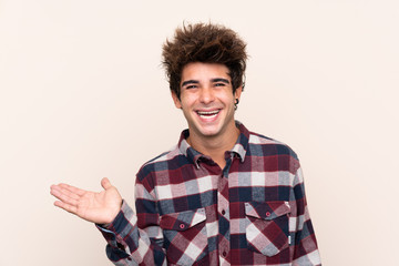 Young caucasian man holding copyspace imaginary on the palm to insert an ad