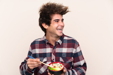 Man holding a bowl full of noodles