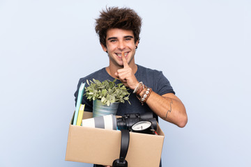 Man making a move while picking up a box full of things doing silence gesture