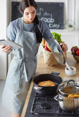 Woman baking at home following recipe on a tablet
