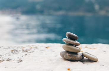 balancing sea stones on the shore of the bay