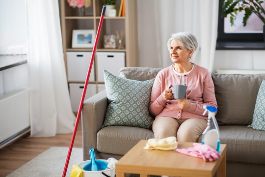 Household And People Concept - Senior Woman Drinking Coffee Or Tea And Resting After Home Cleaning