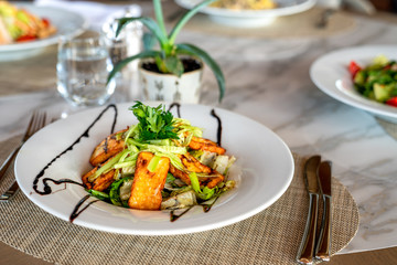 A delicious grilled or roasted hellumi cheese salad is served in a elegance restaurant or hotel.