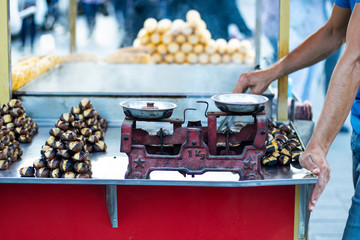 Boiled corn on the wheeled bench and chestnuts cooked on the grill. Photographed in Istanbul, Turkey.