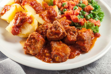 Braised pork meat stew served with potatoes