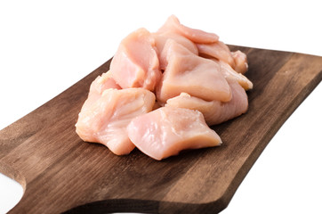Sliced pieces of chicken lie on a wooden board on a white background