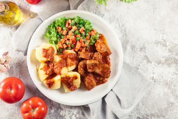 Braised pork meat stew served with potatoes