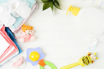 Colorful baby asccessories and clothes flat lay on white wooden background
