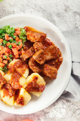 Braised pork meat stew served with potatoes