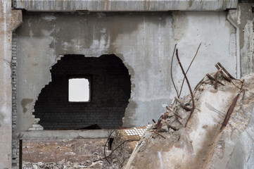 Sharpness on a broken wall. Remnants of the destruction of a large concrete building with a hole in...