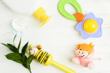 Fototapeta na wymiar Baby shower accessories. Soap, rattles, pacifier and toy on wooden table