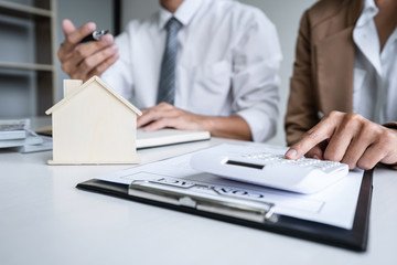 Fototapeta premium Real estate broker agent presenting and consult to customer to decision making sign insurance form agreement, home model, concerning mortgage loan offer for and house insurance