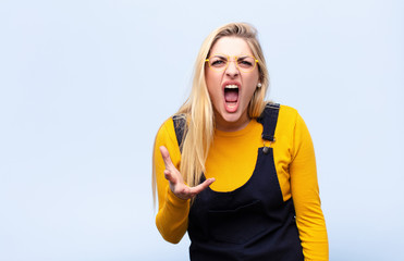 young pretty blonde woman looking angry, annoyed and frustrated screaming wtf or what‚Äôs wrong...
