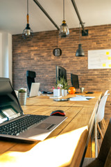 Interior of industrial style coworking office with various workplaces