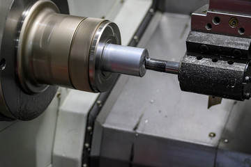 The CNC lathe machine boring cut  at the metal shaft parts. The hi-technology metalworking  manufacturing process by CNC turning machine .