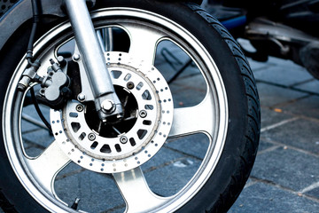 Obraz premium Szczegół zbliżenie przedniego koła motocykla wyścigowego. To jest zacisk hamulca, tarcza, obręcz, opona i zawieszenie. Ścieśniać.