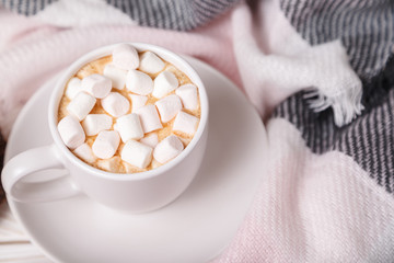 Festive cozy atmosphere. Cup of hot cocoa with marshmallows on background of wool plaid. Mock up. Flatlay