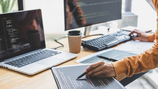 Young Professional programmer working at developing programming and website working in a software develop company office, writing codes and typing data code, Programming with HTML, PHP and javascript