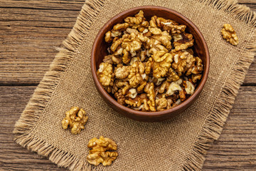 Sprinkled walnuts in ceramic bowl. Natural organic snack, healthy eating concept