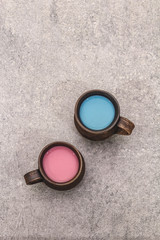 Trendy drink blue and pink latte. Lavender or spirulina and rose, beetroot or raspberry coffee. Stone concrete background