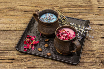 Set of romantic colored coffee latte for two lovers. Lavender and rose, powdered aromatic sugar, spices. Valentines Day concept. Wooden boards background