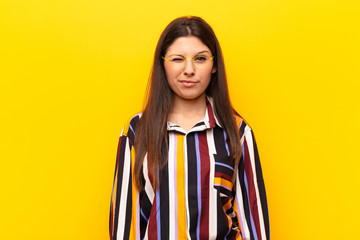 young pretty woman looking happy and friendly, smiling and winking an eye at you with a positive...