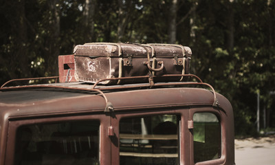 Travel the old fashioned way with a suitcase on an oldtimer car