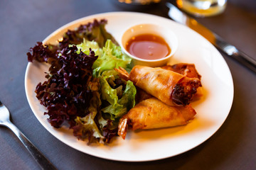 Fried spring rolls with vegetables and shrimps with sauce and salad