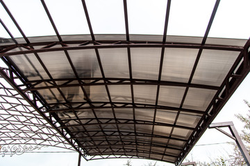 A worker mounts a metal canopy in the courtyard of the house