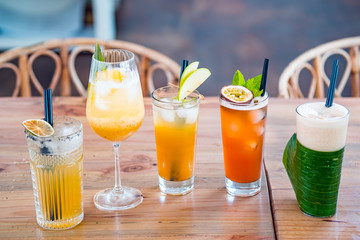 Selection of alcoholic and milkskake cocktails on a wooden table.