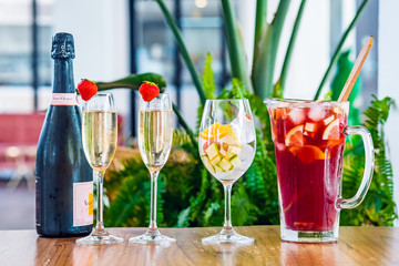 Close-up of a jar with traditional Spanish red wine sangria, champagne bottle and glasses.