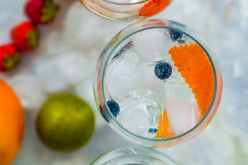 Top view of gin tonic cocktail with blueberries and orange.