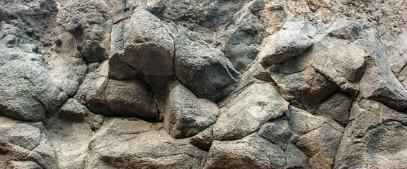 Texture of a stone wall made of lava. Rocks hanging over your head.