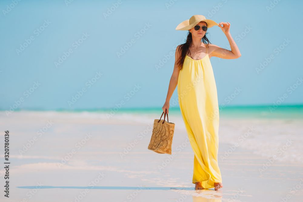 Poster young fashion woman in green dress on the beach