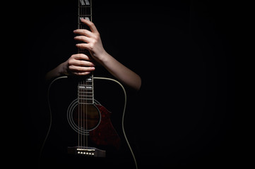 Woman Hugging Her Guitar, Isolated On Black