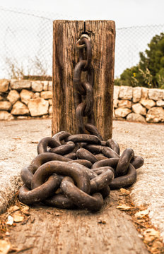 Old wooden column with thick chains
