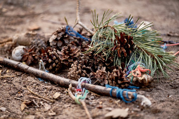 A pile of pine cones on the ground with some needles, blue cords and twigs on the ground created by some children in the forest. Seen in Nuremberg in April 2019