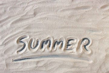 summer message handwritten on white sand background. top view