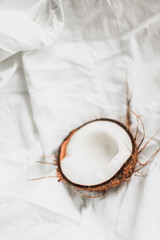 Half a coconut in shell on a white background. Minimalism and raw healthy food concept