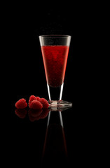 Whisky Rasberry Shrub cocktail with fruit on black background.