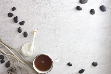 Flat lay picture of spa day with space for copy. Body scrub, hot stones and detox tea