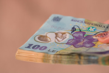Woman hand giving money like bribe or tips isolated . LEI currency banknotes close up. Reward for...