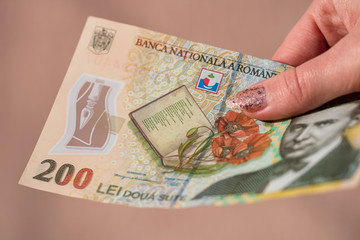Woman hand giving money like bribe or tips isolated . LEI currency banknotes close up. Reward for...