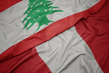 waving colorful flag of peru and national flag of lebanon.