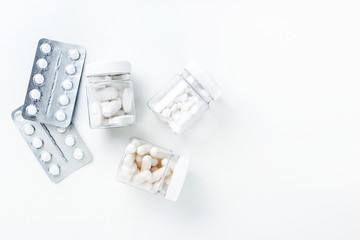 Packages with different white pills and capsules on a white background. Health concept.  Flatlay. Copy space.