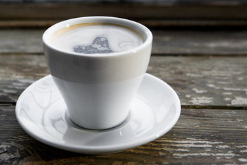 Cup of hot coffee on the wooden table