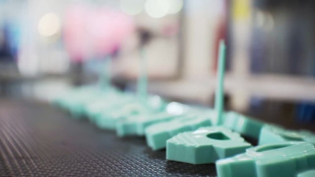 finished plastic parts are moving on a conveyor belt