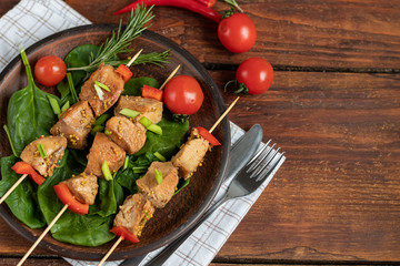 Chicken breast skewers with bell pepper. The meat is marinated in soy sauce with honey and mustard. Decorated with sprigs of rosemary. In the background are soy and vegetables for the salad.