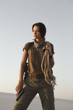 Woman Standing With a Gun Outdoors in Desert